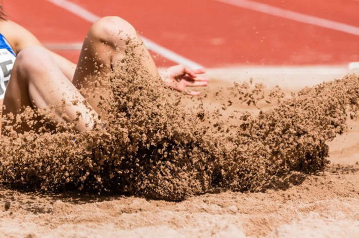 陸上競技走り幅跳びで砂場に着地する選手